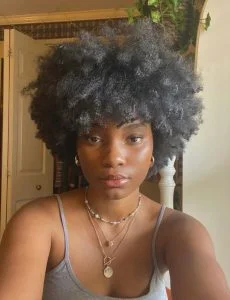 Mulher negra, com cabelo crespo curto