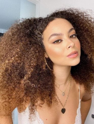 Mulher com cabelo crespo longo e iluminado
