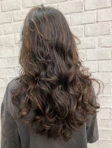 Mulher branca com cabelo longo e repicado