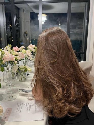 Mulher com cabelo castanho, repicado e longo