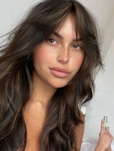 Mulher branca com corte butterfly cut e franja
