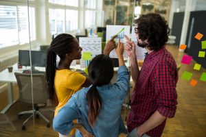 Três pessoas conversando no ambiente de trabalho