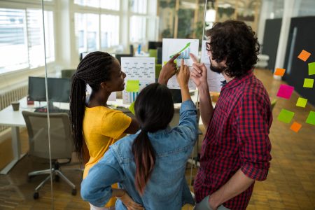 Três pessoas conversando no ambiente de trabalho