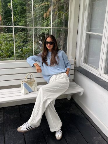 Felicia Akerstrom usando tricô azul claro, calça pantalona branca de alfaiataria e Adidas Samba
