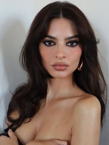 Mulher branca com cabelo escuros, olhos castanhos e maquiagem marcada
