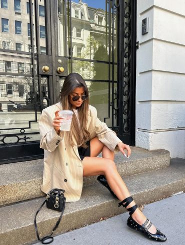 Morgane Renaudi usando blazer na estampa risca de giz, minissaia preta e sapatilha na estética rocker