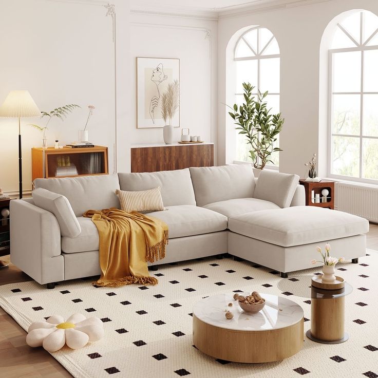 Sala com sofá de cor neutra e paredes brancas