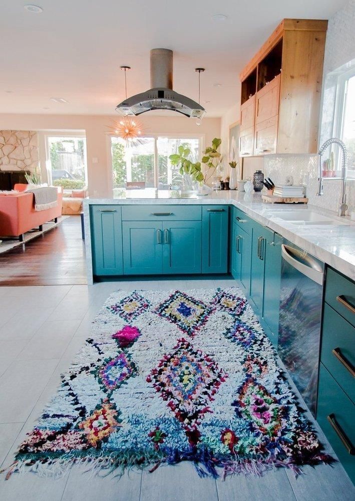 Cozinha com armários azuis e passadeira colorida