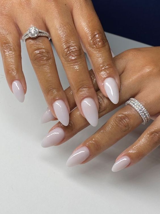 Mãos negras com anéis pratas e unha stiletto branca
