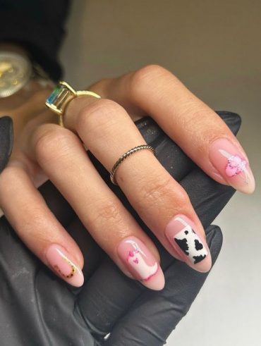 Mão branca com anel apoiada em outra mão, com as unhas amendoadas estilo cowgirl