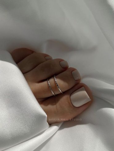 Pé branco com anéis e unha nude claro