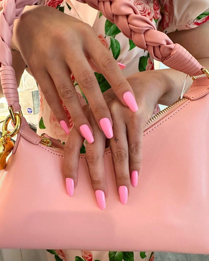 Mãos brancas sobrepostas com unha bailarina rosa chiclete
