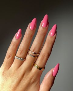 Mão branca com anéis e unha amendoada rosa