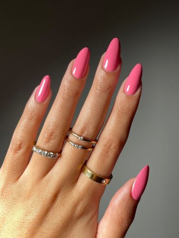 Mão branca com anéis e unha amendoada rosa
