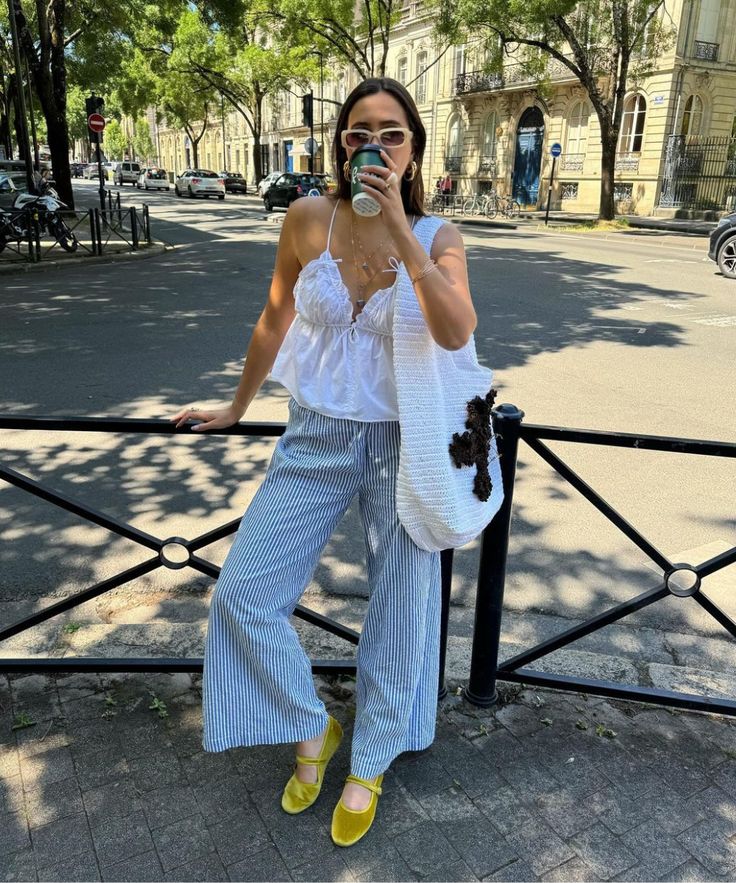 Mulher jovem de pele clara usando calça listrada azul. 5 peças da moda para usar no verão