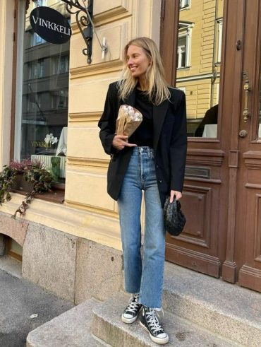 Mulher jovem usando blazer, calça jeans e tênis