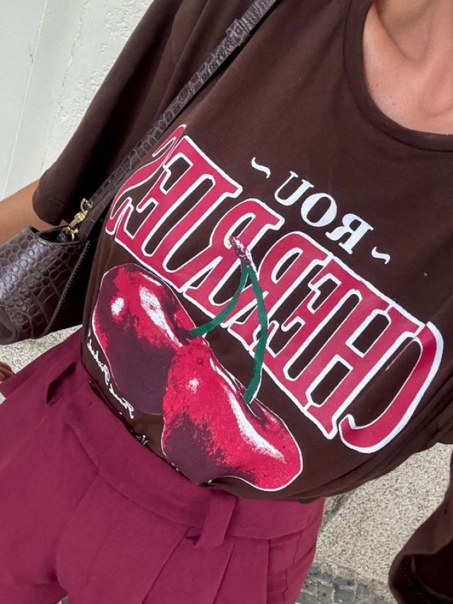 Look com camiseta marrom e estampa de cereja. Com calça de alfaiataria em cor vinho.