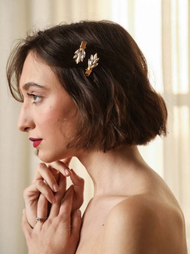 Mulher branca com cabelo curto, em penteado com duas presilhas