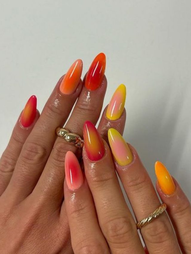 Mãos brancas sobrepostas com anéis e aura nail com laranja e rosado