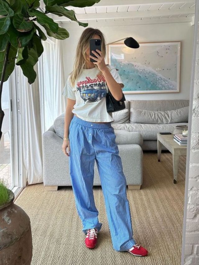 Mulher jovem de pele clara usando calça azul e camiseta.
