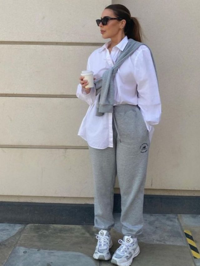 Mulher usando camisa branca, calça de moletom cinza e tênis.