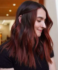 Mulher com cabelo ondulado com balayage ruiva