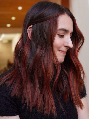 Mulher com cabelo ondulado com balayage ruiva