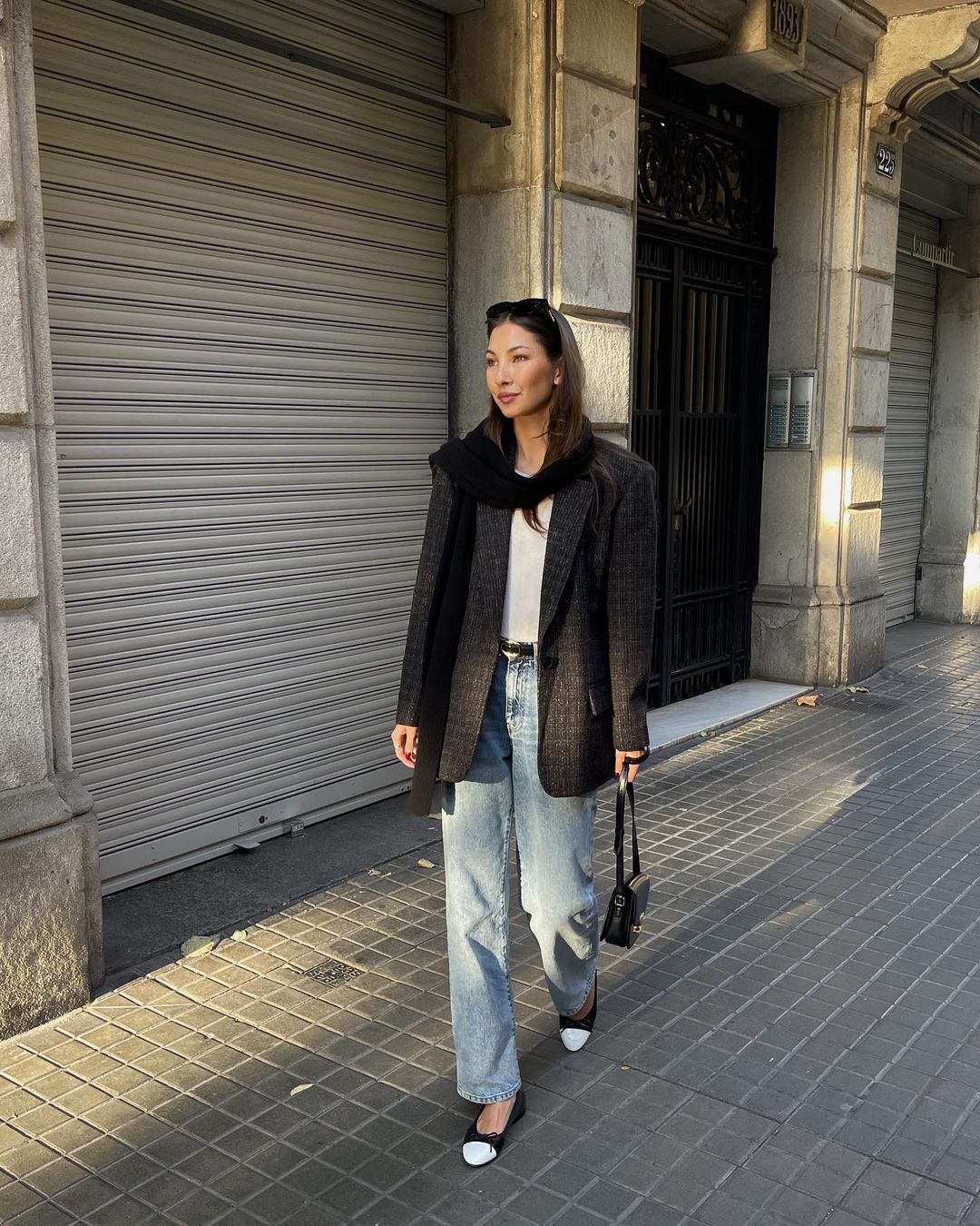 Felicia Akerstrom usando blazer xadrez, calça jeans reta e sapatilha bicolor de bico redondo