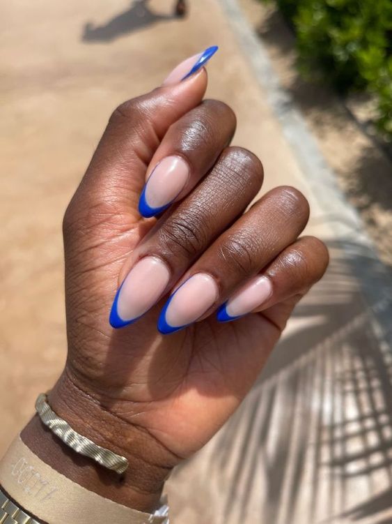 Mão negra curvada com unha amendoada com francesinha azul royal Like Magazine