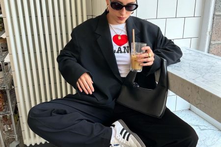 Lara usando blazer preto oversized, baby-tee divertida, bolsa preta básica, calça de alfaiataria e Adidas Samba