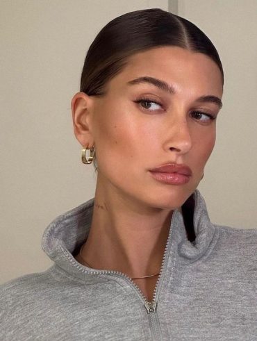 Hailey Bieber com casaco cinza e maquiagem natural