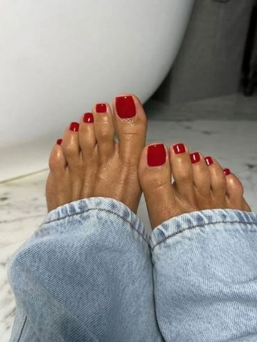 Pés negros com unha vermelho cereja