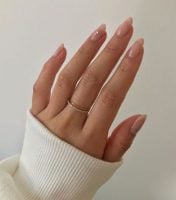 Mão branca com anéis e unha comprida natural
