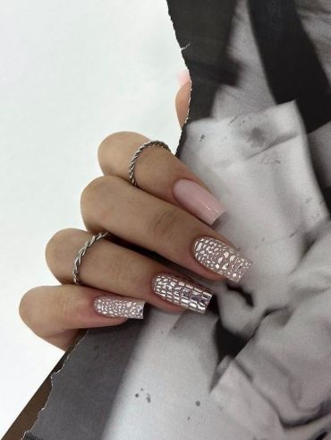 Mão branca com anéis e unha de gel quadrada com aplicações brilhantes