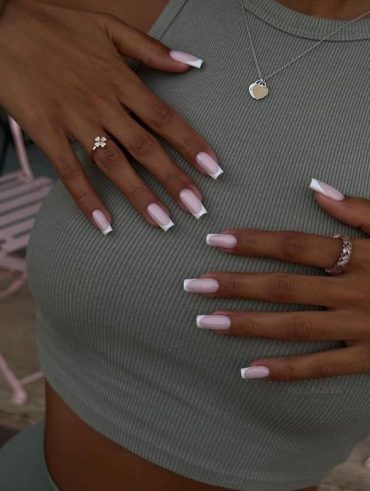 Mãos brancas com anéis, apoiadas no corpo com unha quadrada francesinha