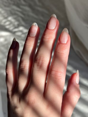 Mão branca com unhas naturais amendoadas