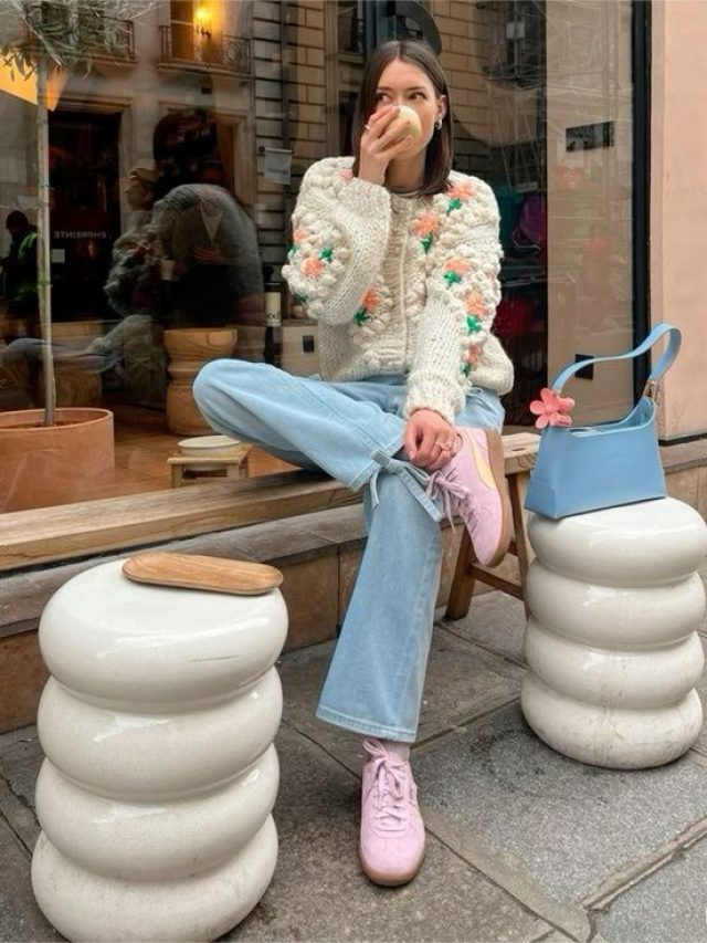 Mulher branca jovem usando cardigan, calça jeans e tênis Puma Palermo rosa