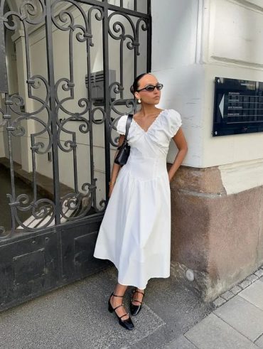 Mulher jovem e magra com, vestido midi branco e sapato boneca preto