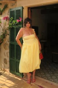 Mulher plus size usando vestido de alcinha em amarelo-manteiga.