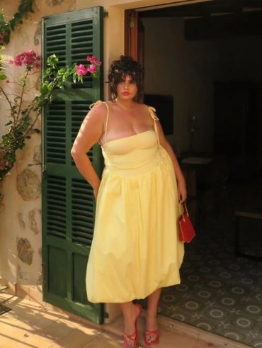 Mulher plus size usando vestido de alcinha em amarelo-manteiga.