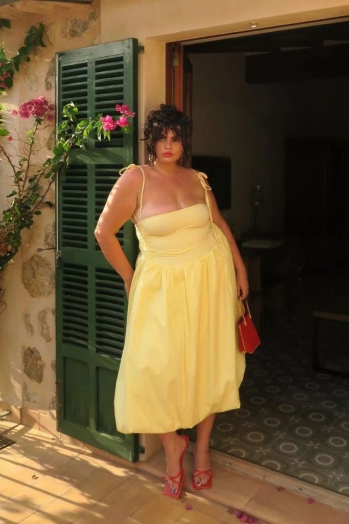 Mulher plus size usando vestido de alcinha em amarelo-manteiga.