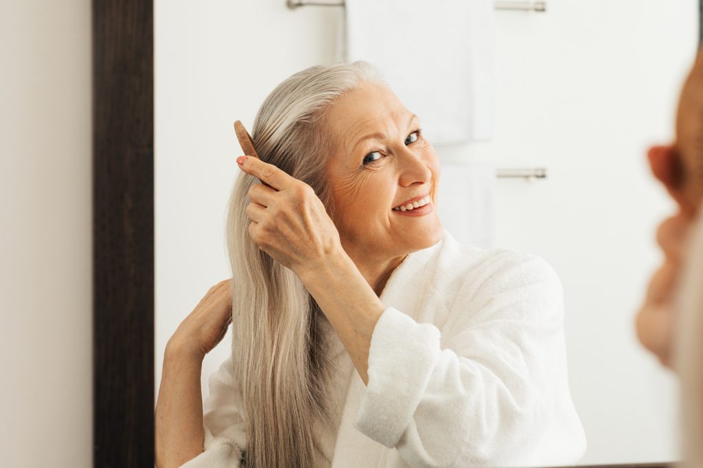 Mulher branca com cabelo longo, liso e grisalho