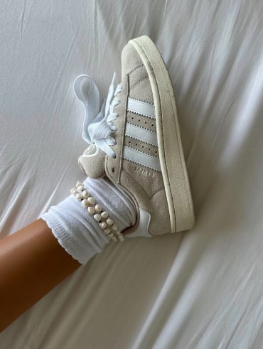 Bérénice usando tênis Adidas, meia branca aparente e tornozeleira de pérolas