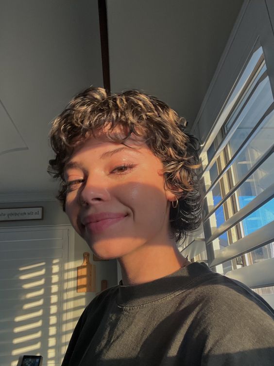 Mulher com corte de cabelo bixie ondulado e maquiagem suave