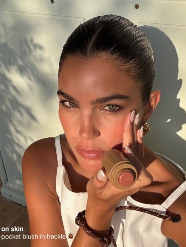 Mulher branca com cabelo preso e maquiagem com blush marrom