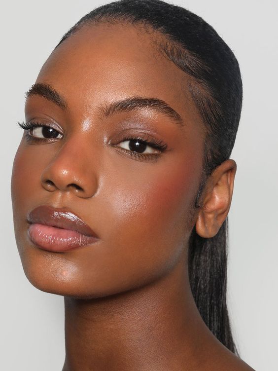 Mulher negra com cabelo preso e blush sun-kissed