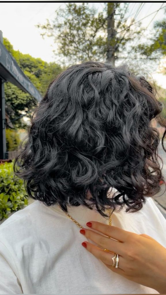 Mulher com cabelo curto e ondulado, de curvatura 2C 