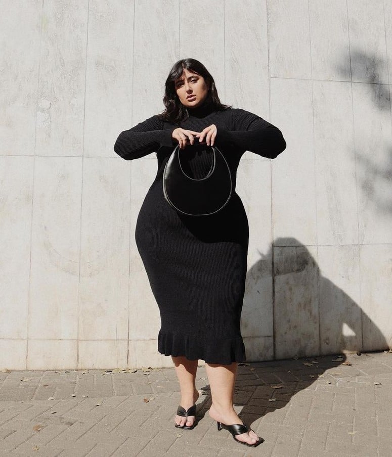 Carla Mortiz usando vestido midi preto, bolsa preta e chinelo kitten heels