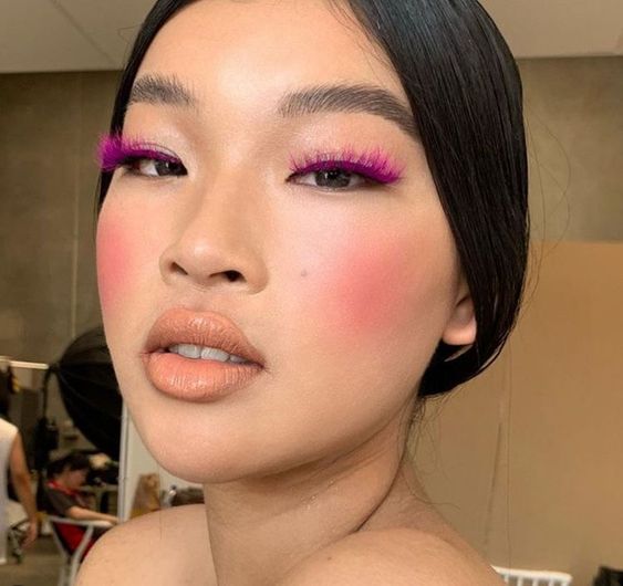 Mulher oriental com máscara de cílios rosa