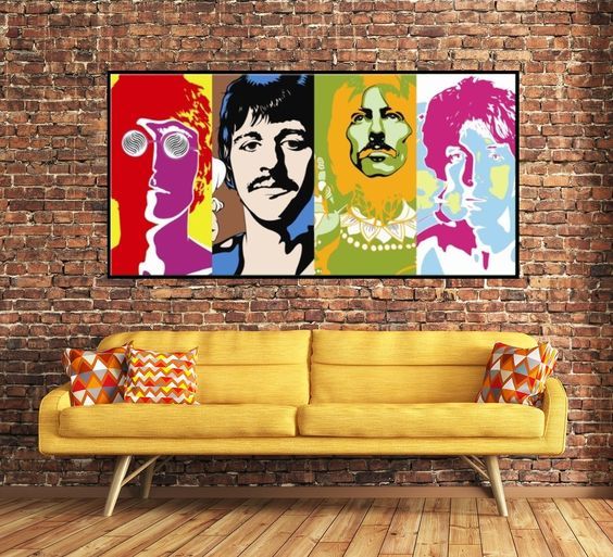 Espaço com sofá amarelo e quadro com Beatles